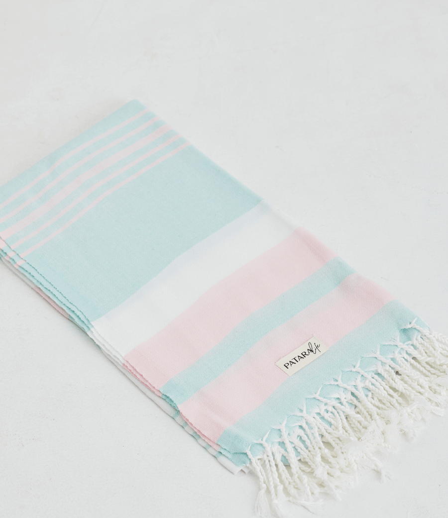 A lightweight peshtemal towel in mint and light pink