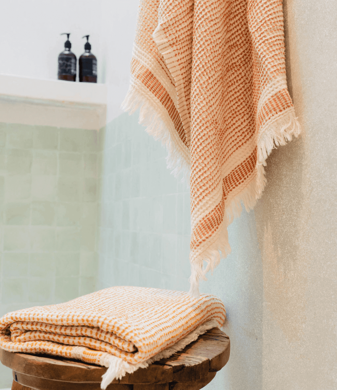 A "Kalkan" beach towel hanging in bathroom and another folded on top of stool