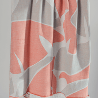 Turkish beach towel in coral and gray patterned with fringed edges