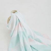 A lightweight peshtemal towel in light pink and mint