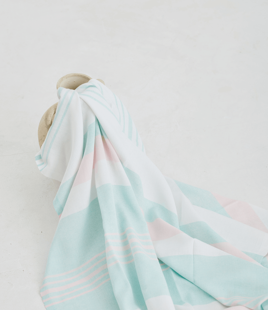 A lightweight peshtemal towel in light pink and mint