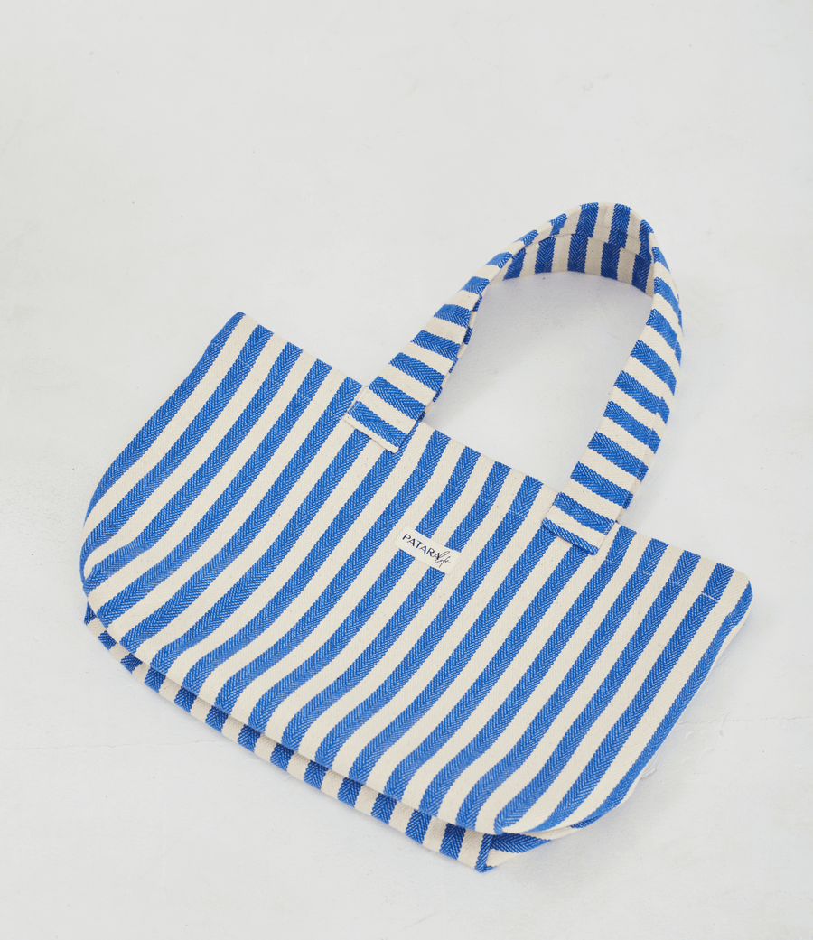 Herringbone woven linen tote bag in Blue stripe layed flat on floor