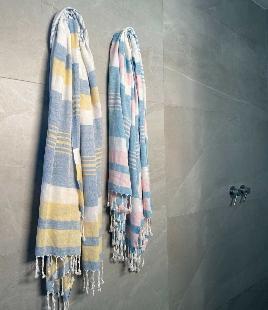 Two lightweight peshtemal towels hanging on bathroom wall