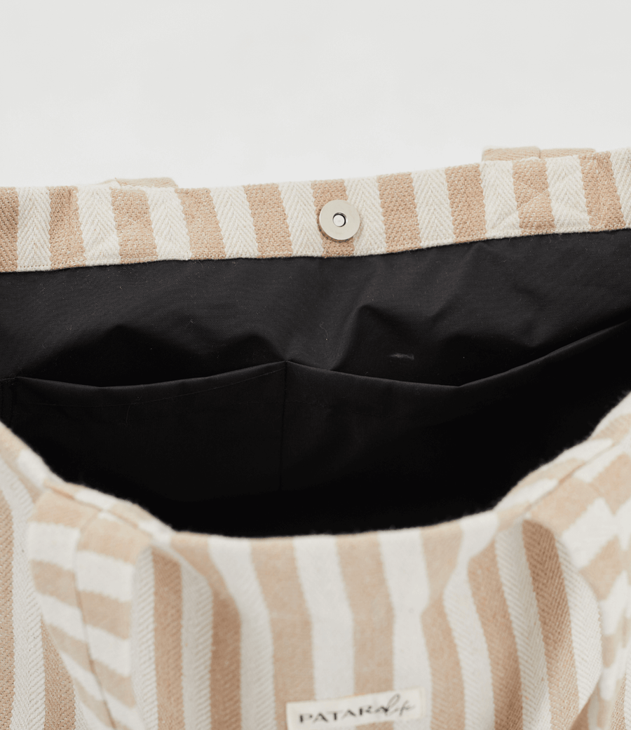 Inside look at Herringbone woven linen tote bag showing black lining and pockets