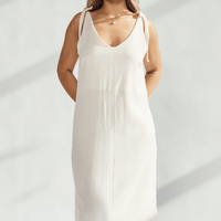 Elegant soft cotton dress with tied straps and subtle leg slits, perfect for refined and comfortable wear.