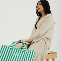 Herringbone woven linen tote bag in Green stripe resting against body