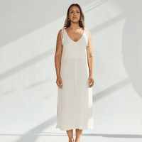 Model wearing a soft cotton dress with tied straps, showcasing a relaxed fit and elegant design.