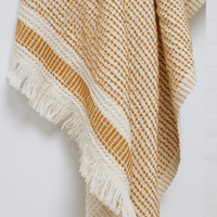 A dotted Turkish cotton "Kalkan" beach towel in mustard yellow