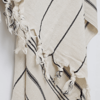 A premium linen "Kekova" Turkish towel in Beige with black stripes